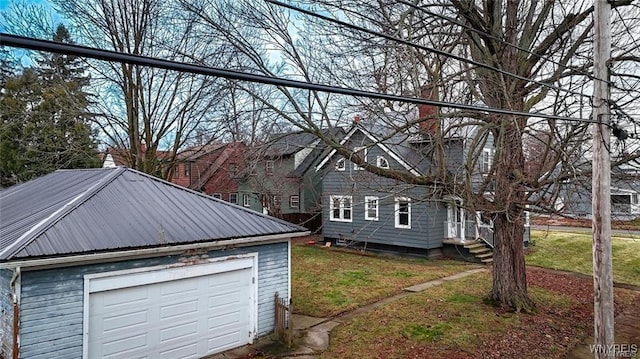 view of side of home with a garage, an outdoor structure, and a yard