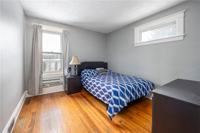 bedroom featuring wood-type flooring and multiple windows