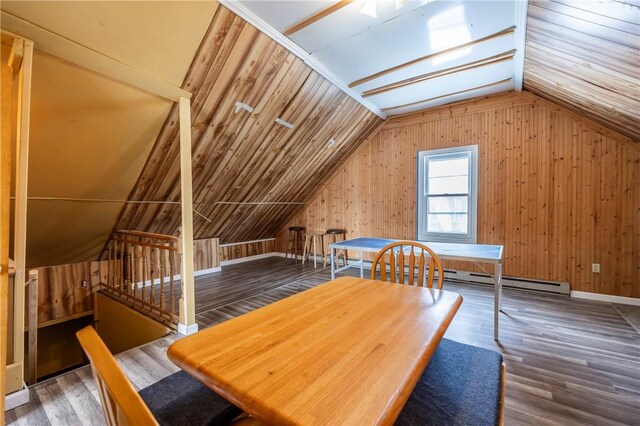 additional living space featuring a baseboard heating unit, lofted ceiling, dark wood-type flooring, and wooden walls