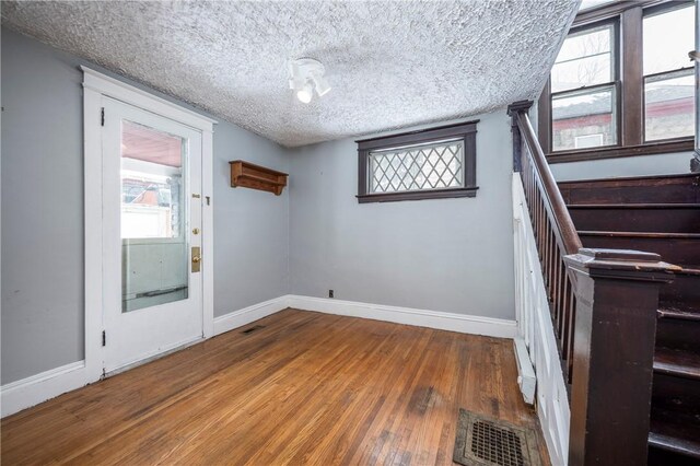 empty room featuring wood-type flooring and a textured ceiling