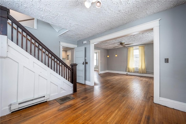 interior space with ceiling fan, hardwood / wood-style floors, a textured ceiling, and baseboard heating