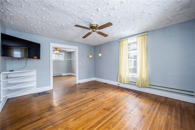 unfurnished living room with a baseboard heating unit, hardwood / wood-style flooring, a textured ceiling, and ceiling fan