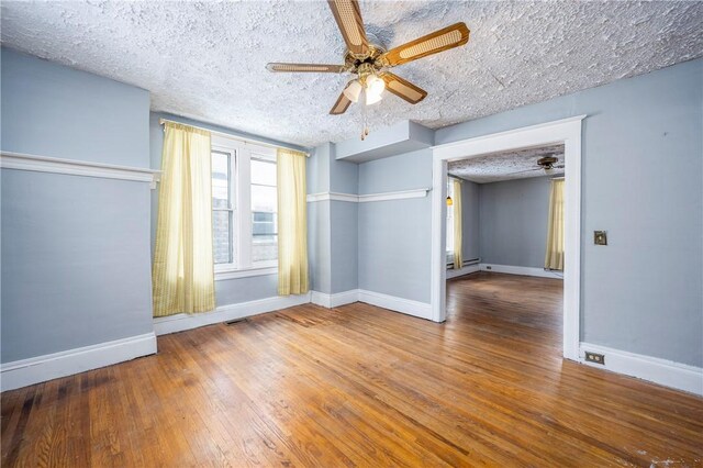 unfurnished room with hardwood / wood-style flooring, ceiling fan, and a textured ceiling