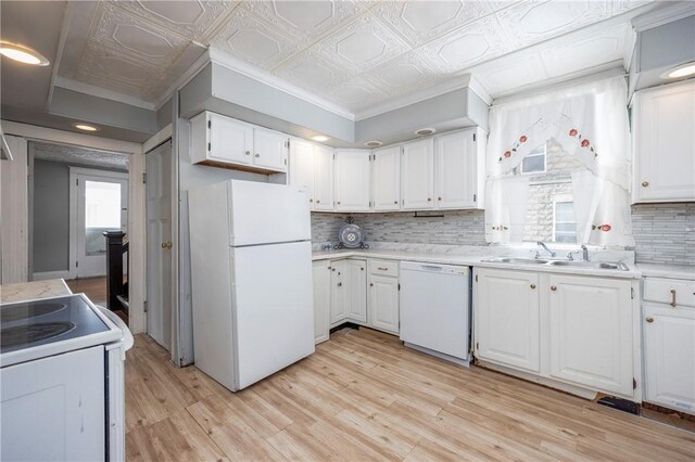 kitchen with sink, white cabinetry, light wood-type flooring, white appliances, and decorative backsplash