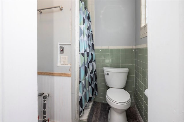 bathroom with tile walls, hardwood / wood-style floors, and toilet