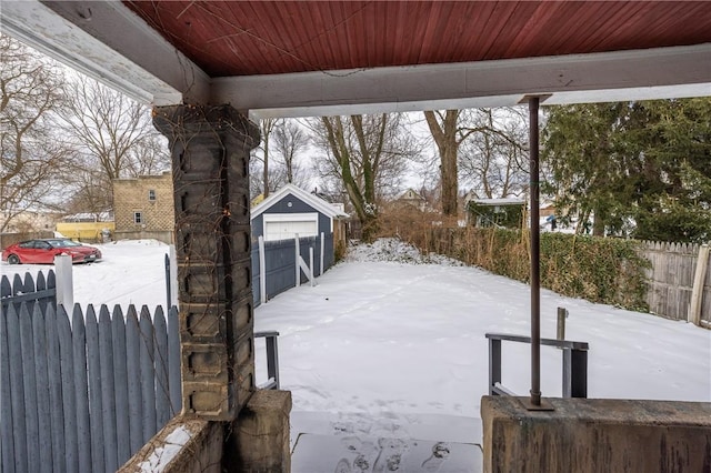 yard covered in snow with a garage and an outbuilding