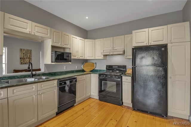 kitchen featuring sink, light hardwood / wood-style flooring, and black appliances