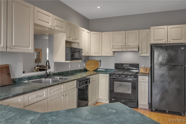 kitchen with light hardwood / wood-style floors, sink, and black appliances