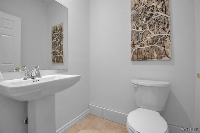 bathroom featuring sink, toilet, and tile patterned flooring