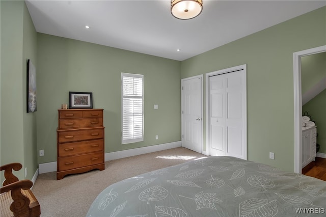 bedroom with light carpet, a closet, and ensuite bathroom