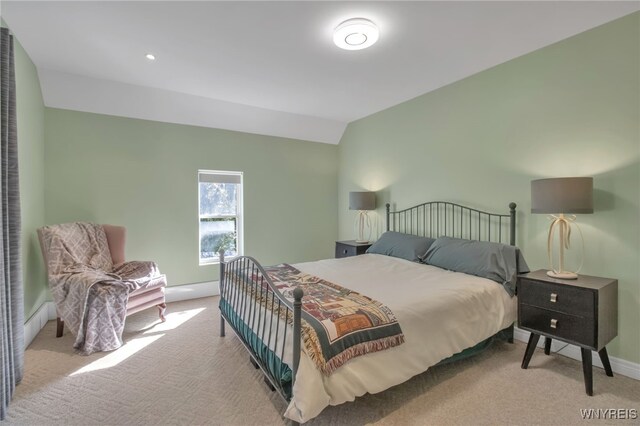 bedroom with light colored carpet and vaulted ceiling