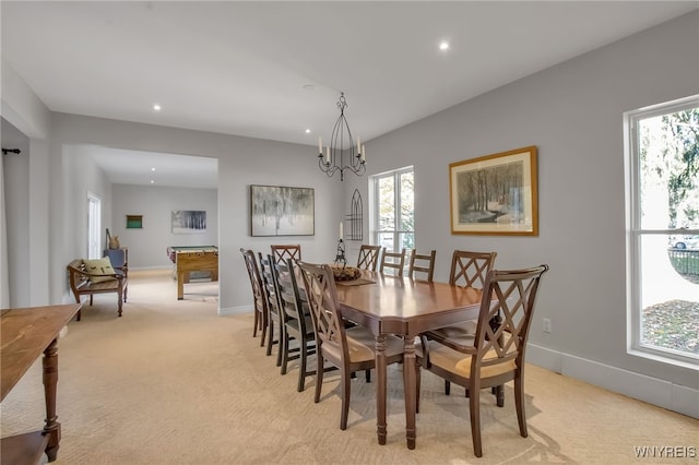 carpeted dining space featuring a notable chandelier