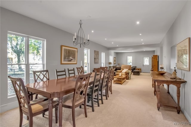 carpeted dining room with an inviting chandelier