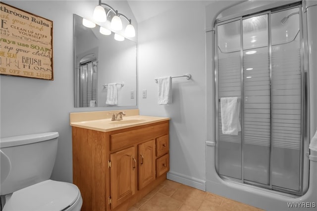 bathroom featuring tile patterned flooring, vanity, an enclosed shower, and toilet