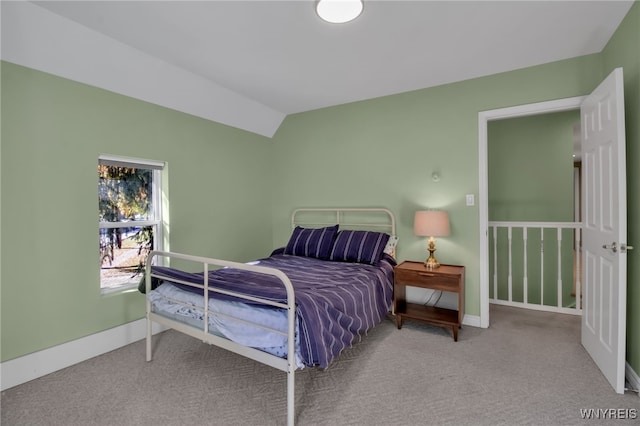 carpeted bedroom with lofted ceiling