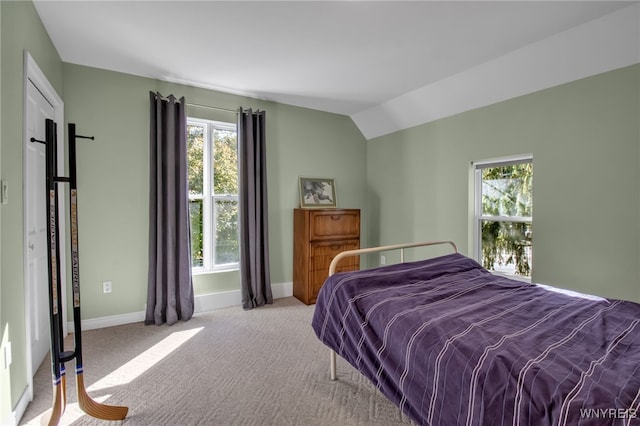 carpeted bedroom with lofted ceiling