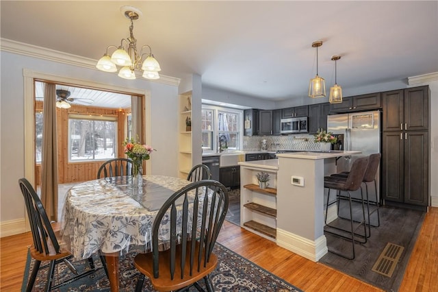 dining room featuring crown molding, a healthy amount of sunlight, and dark hardwood / wood-style flooring