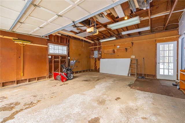 garage with a garage door opener and electric panel