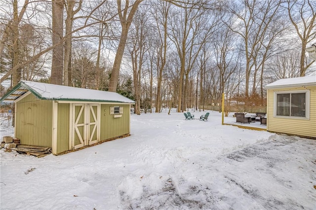 snowy yard featuring a shed