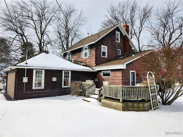 snow covered property with a wooden deck