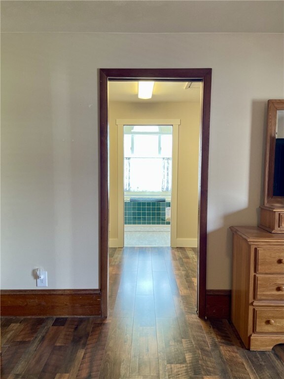 hall with dark wood finished floors and baseboards