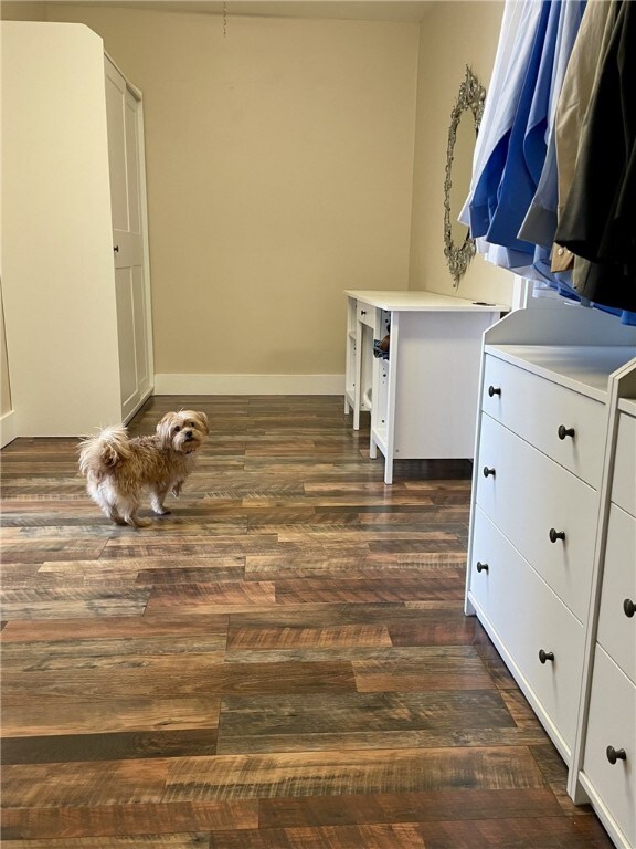 washroom featuring dark wood finished floors and baseboards