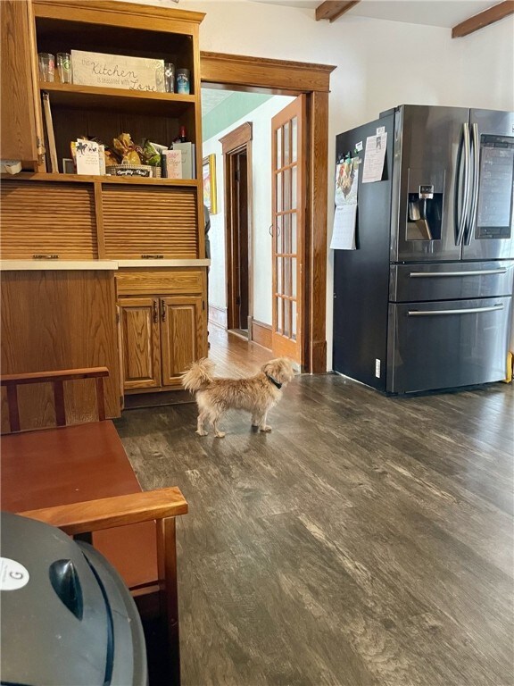interior space featuring dark wood finished floors and beam ceiling