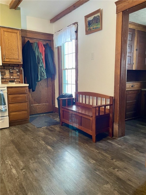 interior space featuring beam ceiling and dark wood finished floors
