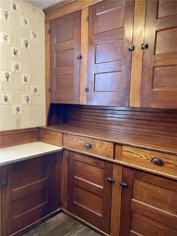 kitchen featuring brown cabinetry and dark wood-style flooring
