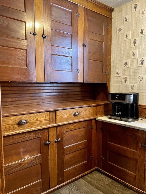 kitchen with brown cabinetry and dark wood-type flooring