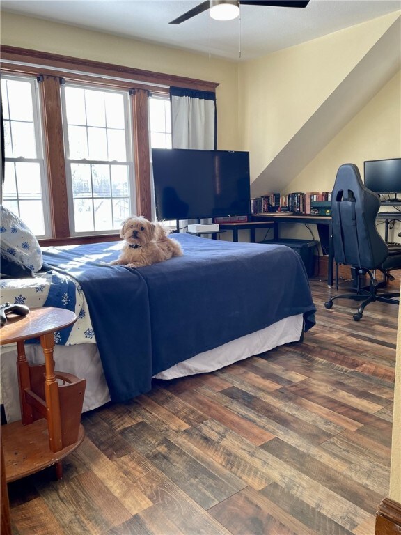 bedroom with ceiling fan, multiple windows, lofted ceiling, and wood finished floors