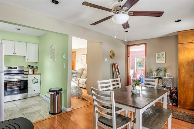 dining area with ceiling fan, a baseboard radiator, and light hardwood / wood-style floors