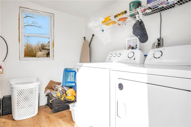 laundry area featuring washing machine and clothes dryer and light hardwood / wood-style flooring