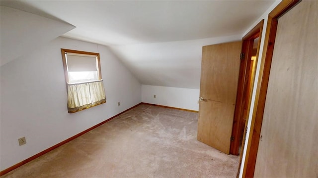 bonus room featuring vaulted ceiling and light colored carpet