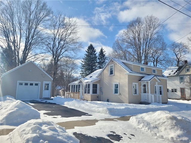 view of snow covered exterior featuring a garage and an outdoor structure