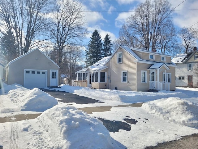 view of snowy exterior with a garage and an outdoor structure