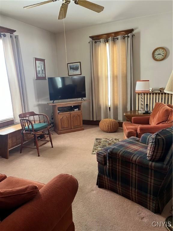 carpeted living room featuring ceiling fan