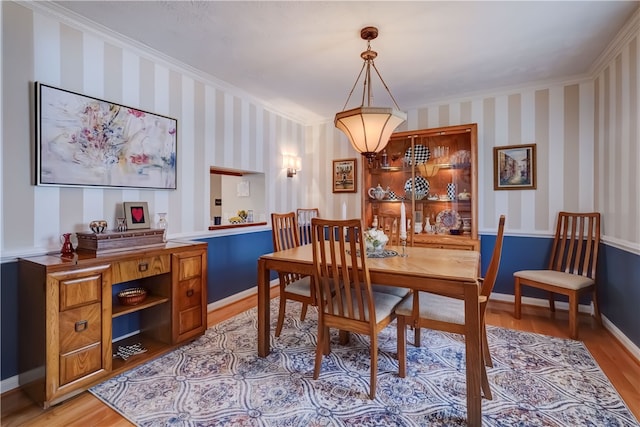 dining area featuring ornamental molding and light hardwood / wood-style floors