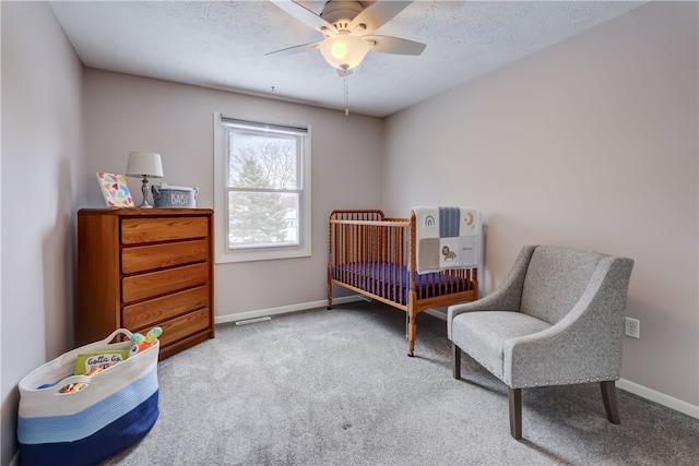 carpeted bedroom featuring ceiling fan and a textured ceiling