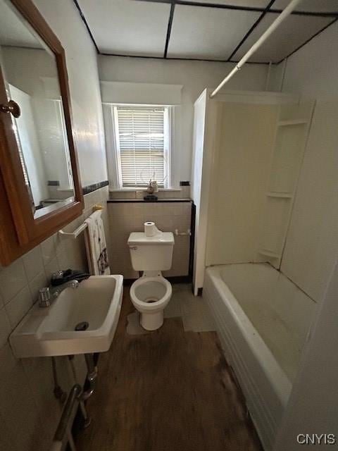 full bathroom with hardwood / wood-style flooring, sink, tile walls, and toilet