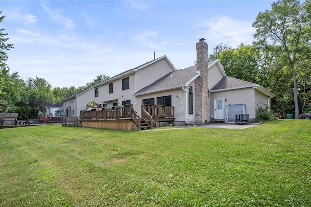 rear view of property featuring a wooden deck and a lawn