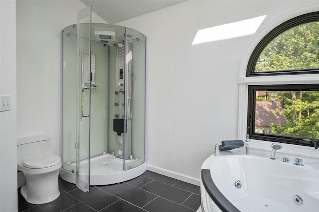 bathroom with a skylight, toilet, independent shower and bath, and tile patterned flooring