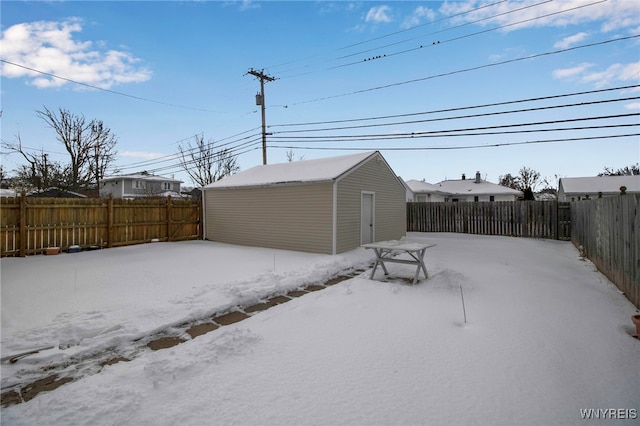 yard layered in snow with an outbuilding