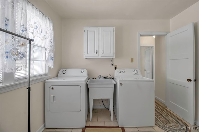 laundry area with cabinets, washing machine and dryer, sink, and light tile patterned floors