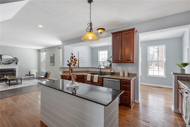 kitchen with sink, decorative light fixtures, plenty of natural light, dark hardwood / wood-style floors, and dishwasher