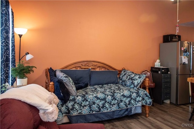 bedroom featuring dark wood-type flooring and stainless steel refrigerator