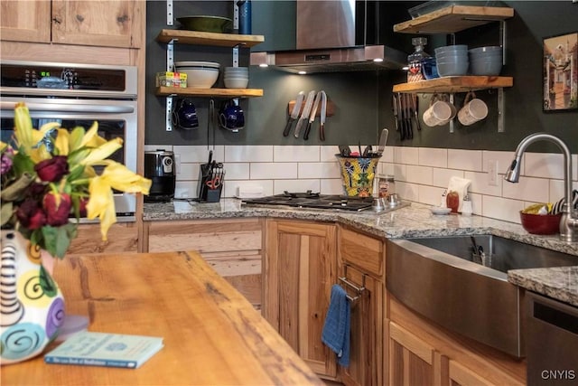 kitchen featuring stainless steel appliances, tasteful backsplash, light stone countertops, and sink