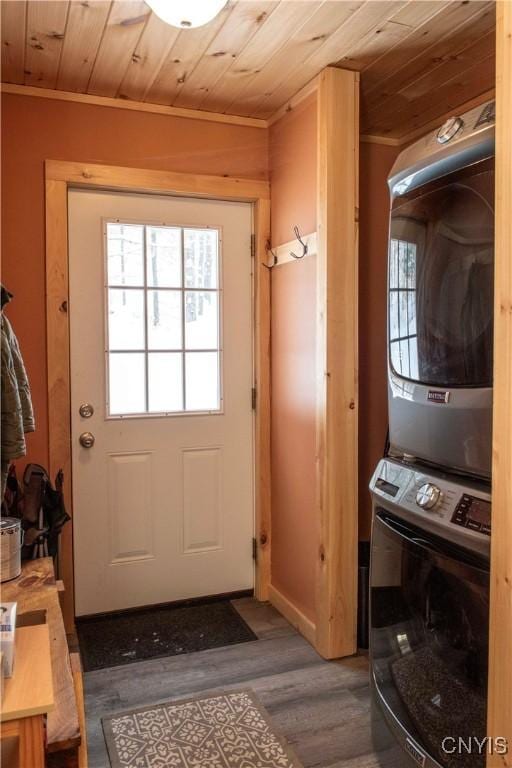 entryway with crown molding, wood ceiling, dark hardwood / wood-style floors, and stacked washer and clothes dryer