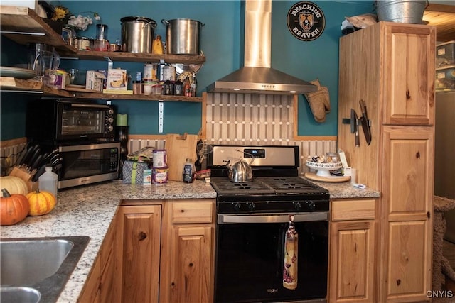 kitchen with light stone countertops, appliances with stainless steel finishes, and exhaust hood