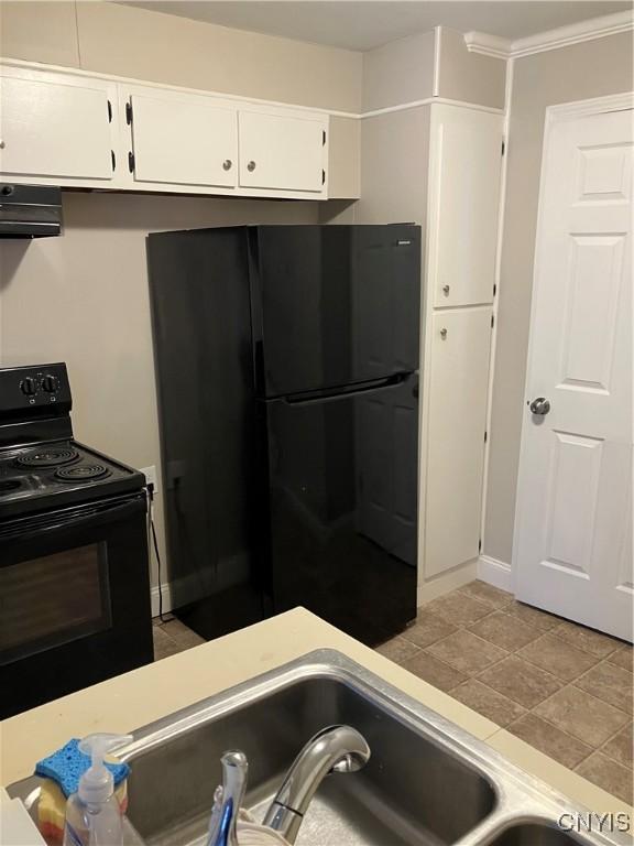 kitchen featuring white cabinetry, range hood, light tile patterned floors, and black appliances